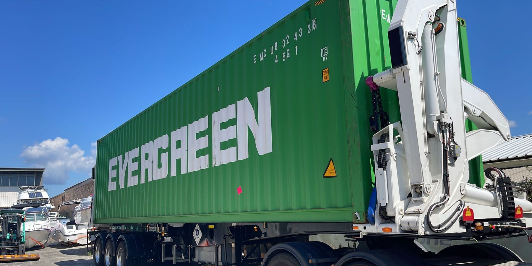An Aardiv side loader carrying a 40-foot shipping container